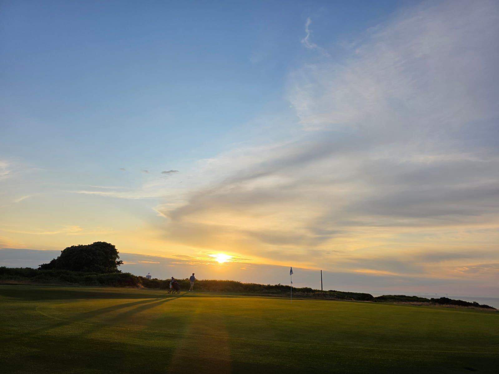 Royal Cromer — golfers on the green at sunset with sea behind